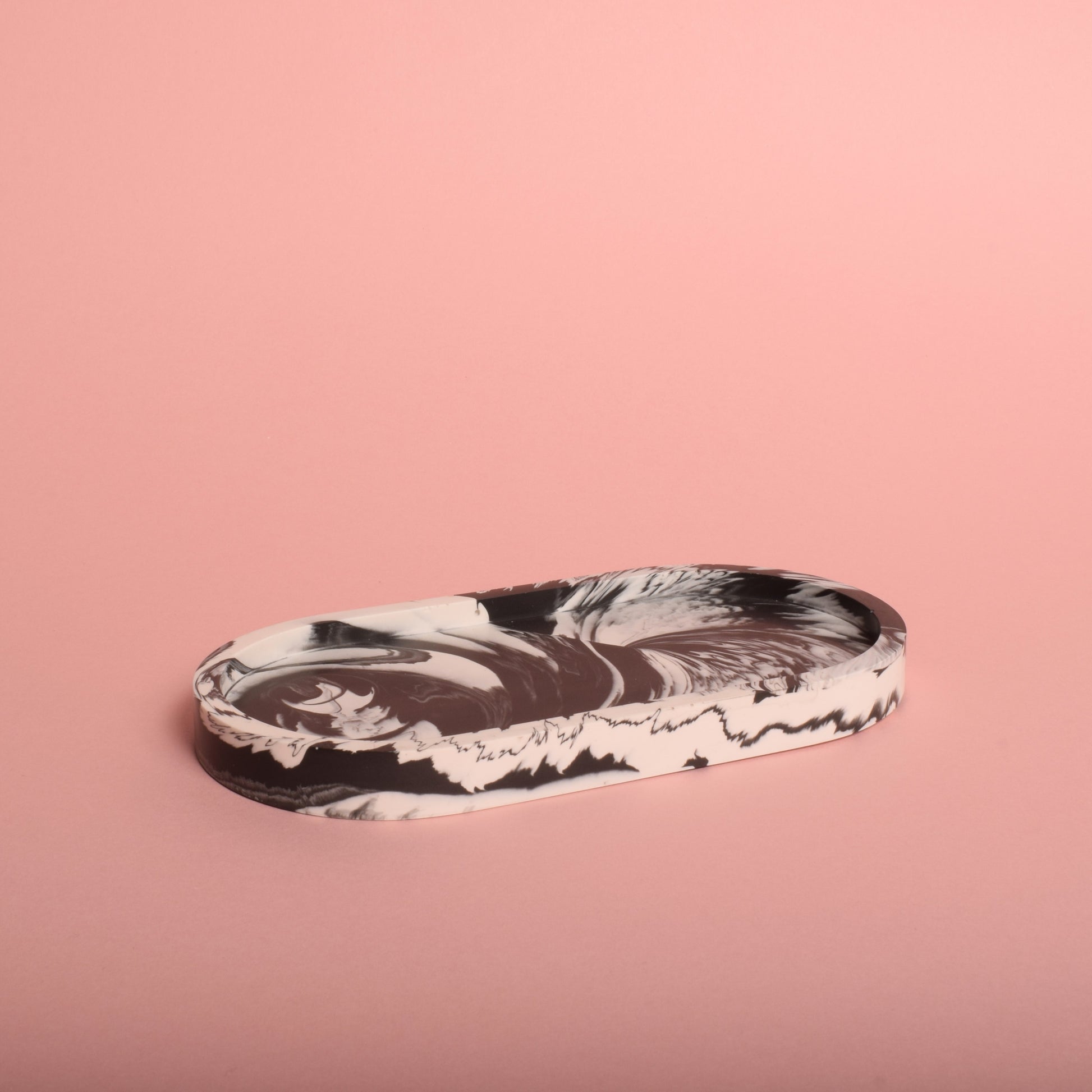 A black and white oval-shaped marble effect trinket tray