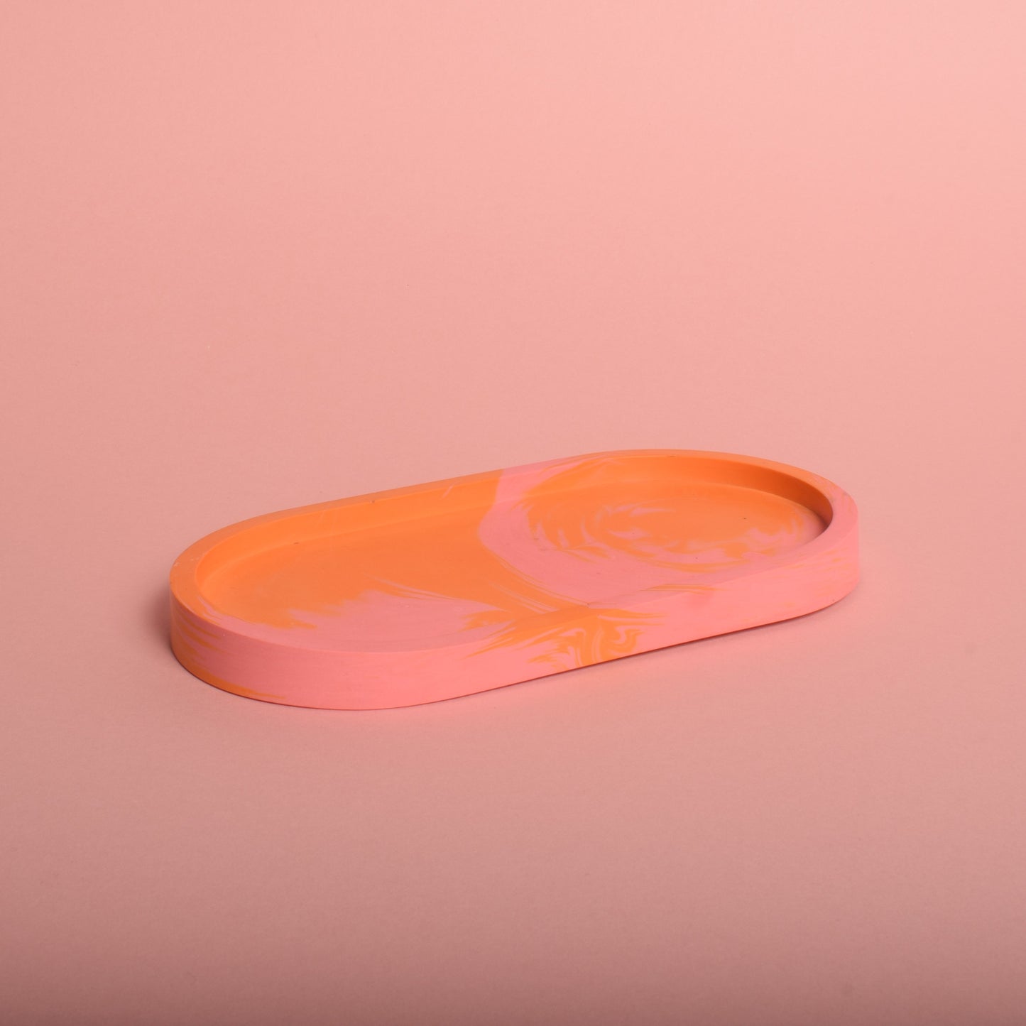 An oval marble effect pink and orange trinket tray.